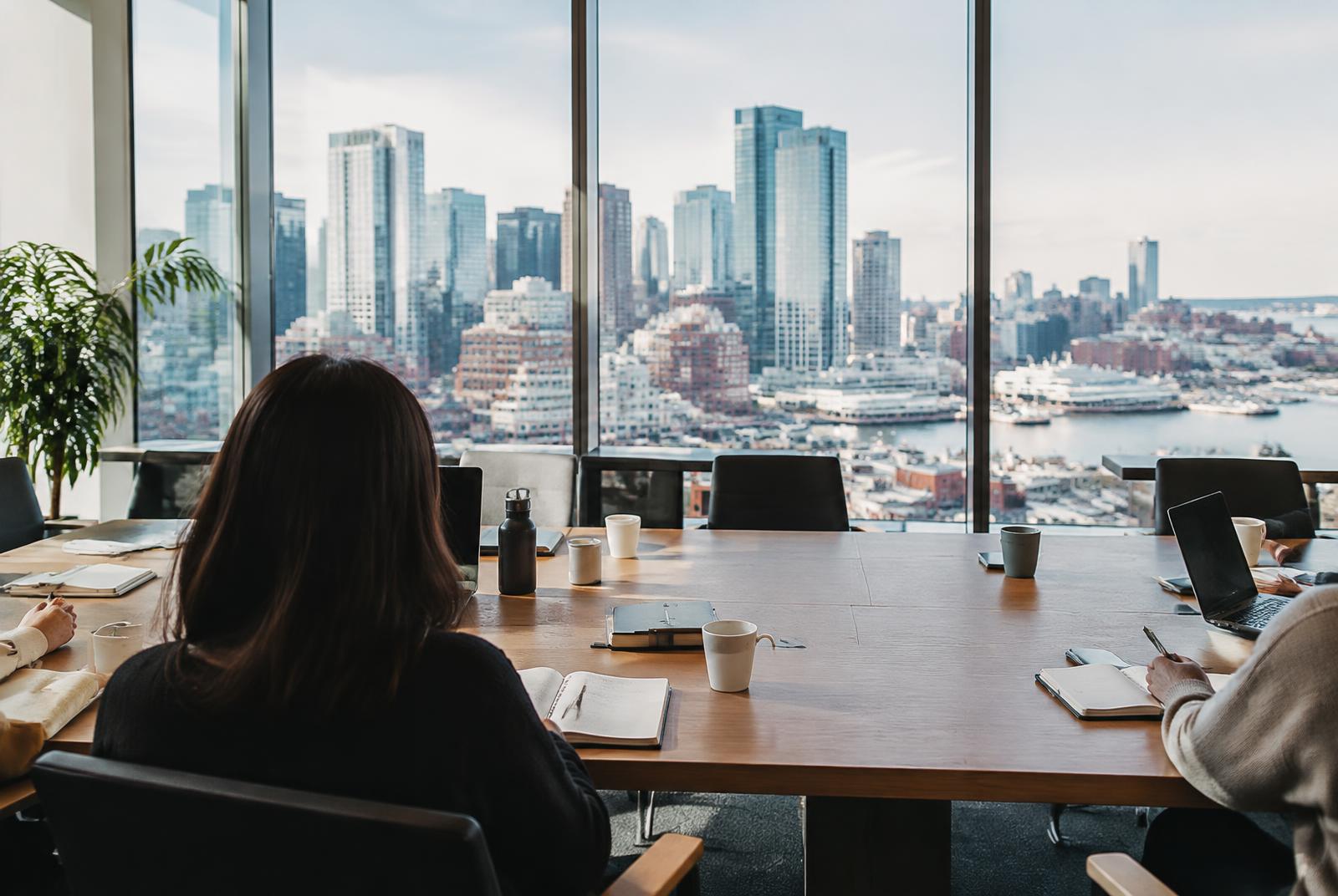 Boardroom workshop with notebooks and a view of the Boston skyline